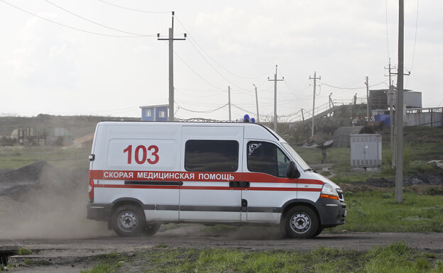 Ein Rettungswagen rast eine staubige Straße in der Ukraine entlang.