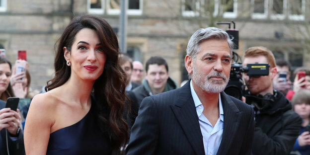 Amal Clooney und George Clooney, dahinter Fotografen