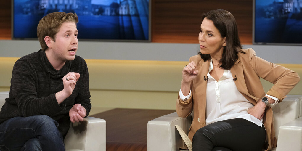 Kevin Kühnert und Anne Will sitzen sich gegenüber auf Sesseln im Sendestudio