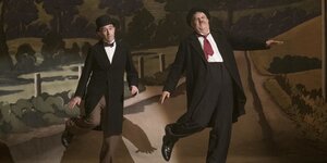 Schauspieler stellen Laurel und Hardy tanzend auf einer Bühne dar