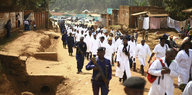 Ärzte laufen in weißer Kleidung eine Straße entlang