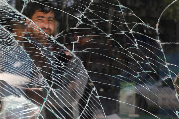Ein Mann schaut durch eine gebrochene Fensterscheibe in Kabul, Afghanistan