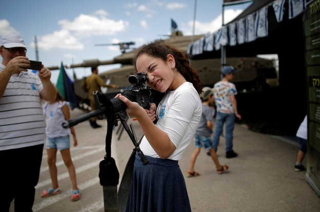 Ein israelisches Mädchen hält ein Gewehr in der Hand und schaut durch das Zielfernrohr