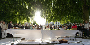 Brot und Blumen liegen auf einem Tisch anlässlich eines Gottesdienstes unter freiem Himmel.