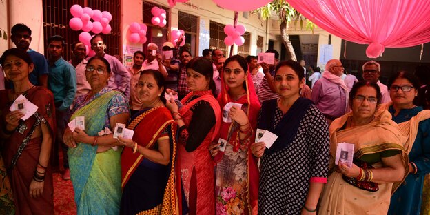 Frauen in Sari in einer Wahlschlange