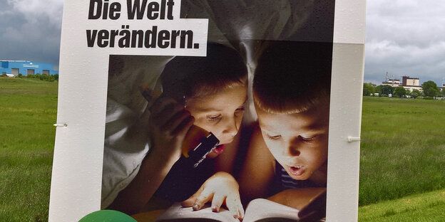 Zwei Kinder lesen unter der Bettdecke.