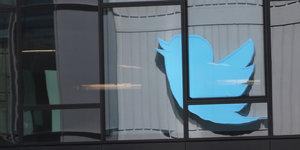 Das Logo des Kurznachrichtendienstes Twitter spiegelt sich in einer Fensterfassade