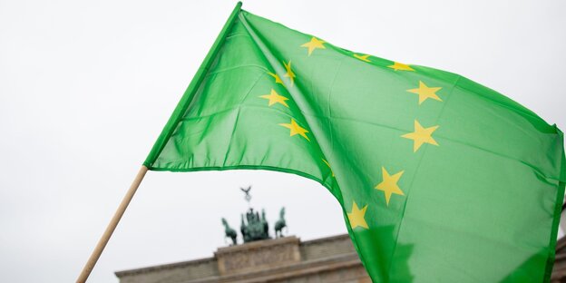 Eine grüne Fahne mit den Sternen Europas weht am Brandenburger Tor