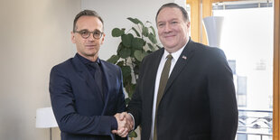 Heiko Maas gibt Mike Pompeo die Hand, beide schauen in die Kamera