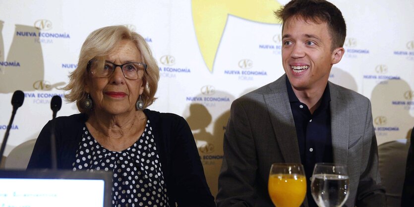 Manuela Carmena und Iñigo Errejón sitzen vor Mikrofonen