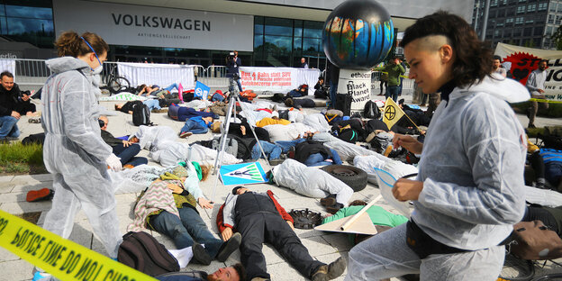 AktivistInnen in weißen Overalls beim Protest vor der VW-Hauptversammlung in Berlin