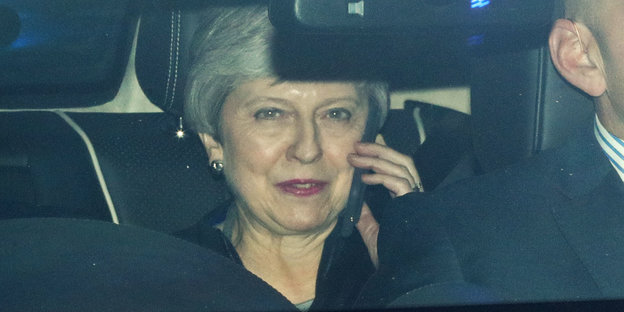 Eine Frau sitzt im Auto und telefoniert. Es ist Theresa May