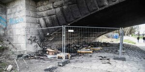 Unter einer Brücke liegen verbrannte Gegenstände