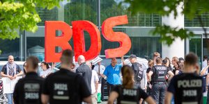 Menshcne halten drei große Buchstaben BDS in die Luft