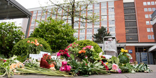 Blumengebinde liegen vor einem Eingang des Universitätsklinikums