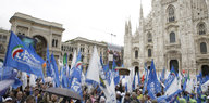 Vor dem Dom in Mailand ist eine große Menschenmenge mit vielen blau-weißen Fahnan