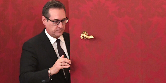 Strache geht durch eine rote Tür mit einer goldenen Klinke