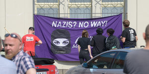 Teilnehmer einer Gegendemonstration gegen einen Marsch der rechtsgerichteten Szene hängen in der Innenstadt ein Plakat mit der Aufschhrift "Nazis? No way!" auf