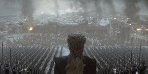 Game-of-Thrones-Szene: Frau von hinten, vor ihr Truppen in einer zerstörten Stadt