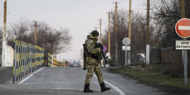 Ein Soldat patrouilliert am Checkpoint Hnutove