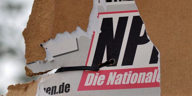 Ein Wahlplakat der Partei NPD wurde offenbar abgerissen, es hängen nur noch Teile davon