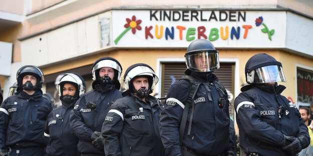 Polizisten stehen vor einem Kinderladen