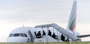 Abgelehnte Asylbewerber steigen in ein Flugzeug