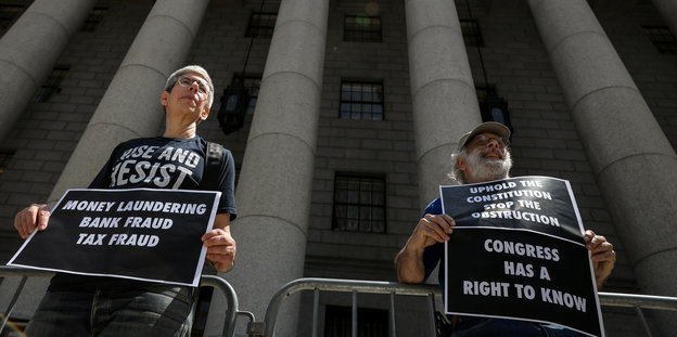 Zwei Demonstrierende stehen vor einem Gerichtsgebäude in New York und fordern die Veröffentluchung von Trumps Finanzen