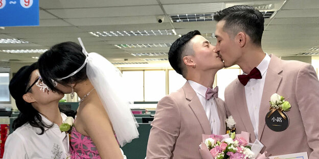 Zwei Paare küssen sich nachdem sie geheiratet haben