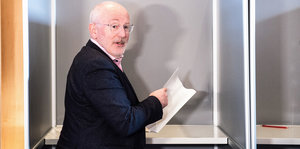 Frans Timmermans in der Wahlkabine, er dreht sich zur Fotografin um