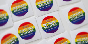 Regenbogenfarbene Aufkleber mit der Aufschrift "Refugees welcome".