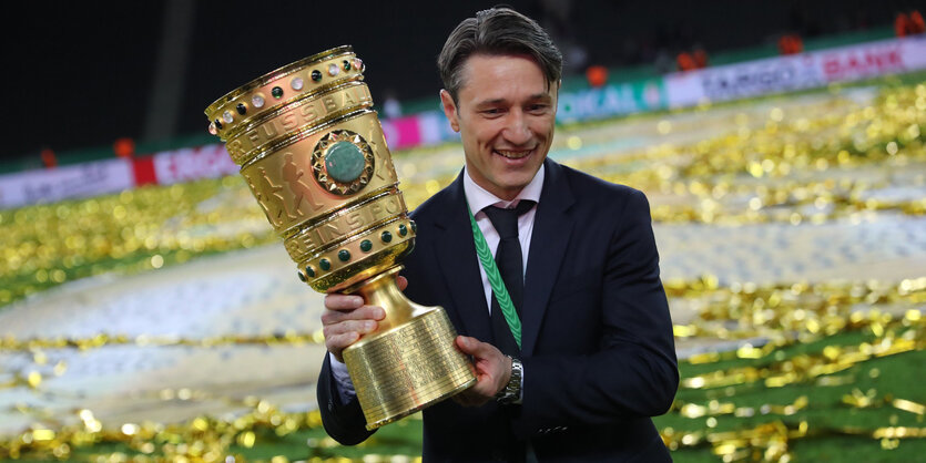 ein Mann mit einem großen Pokal