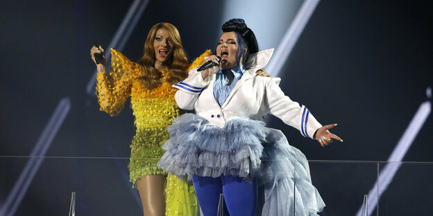 Zwei Frauen singen in auffälligen Outfits