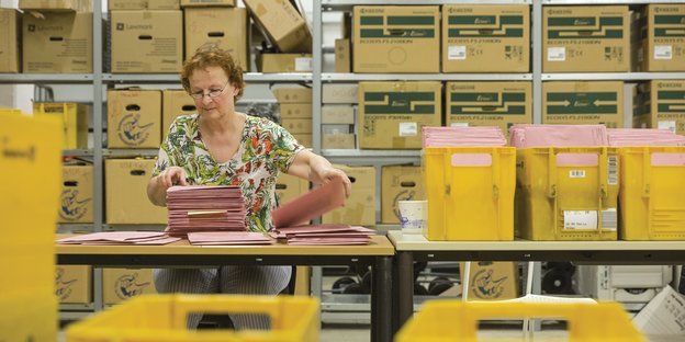 Eine Mitarbeiterin des Bremer Wahlamts sortiert Briefwahl-Unterlagen.
