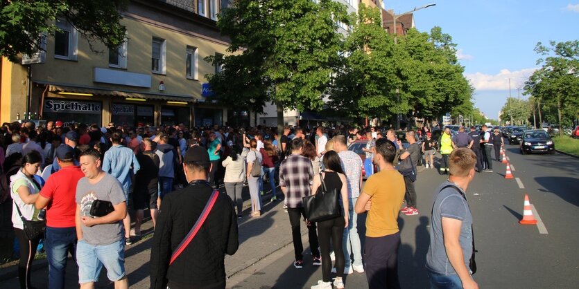 Viele Menschen stehen in einer Schlange auf der Straße