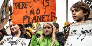 für mehr Klimaschutz protestierende Jugendliche auf der Straße mit Schildern, auf einem steht auf Englisch: Es gibt keinen Planeten B