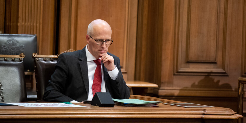 Hamburgs Bürgermeister Peter Tschentscher sitzt mit angespanntem Gesichtsausdruck in der Hamburgischen Bürgerschaft.