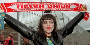 Eine Frau posiert mit gespitzten Lippen und Fan-Schal von Union Berlin