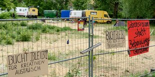 Blick auf die mit Bauwägen und Zelten besetzte Brachfläche an der Rummelsburger Bucht. Am Bauzaun hängen Transparente mit der Aufschrift "Bucht bleibt.