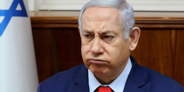 Benjamin Netanjahu, im Hintergrund eine israelische Flagge.