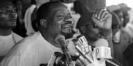 Schwarz-Weiß-Aufnahme: Jonas Savimbi spricht vor Mikrofonen