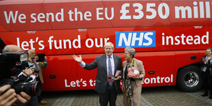 Boris Johnson steht vor einem Bus