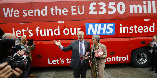 Boris Johnson steht vor einem Bus