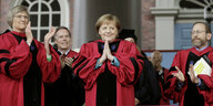 Angela Merkel lächelt und hält die Handflächen gegeneinander