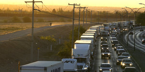 Lastwagen und Autos stehen auf einer Autobahn