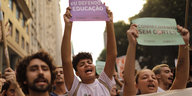 Junge Demonstrierende halten Plakate hoch