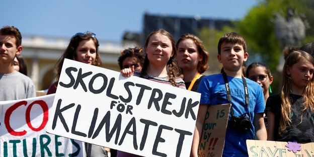 Greta Thunberg bei einer Kundgebung mit Pappschild