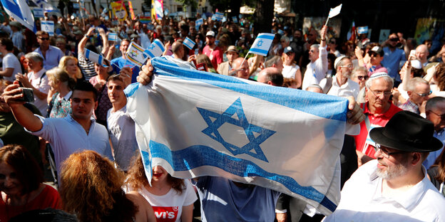 Eine große Menschenmenge ist zu sehen, einige halten Israelfahnen hoch