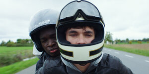 Zwei junge Männer auf einem Motorrad