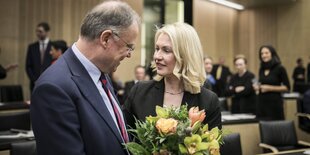 Stephan Weil und Manuela Schwesig sprechn miteinander, Weil hält einen Blumenstrauß im Arm